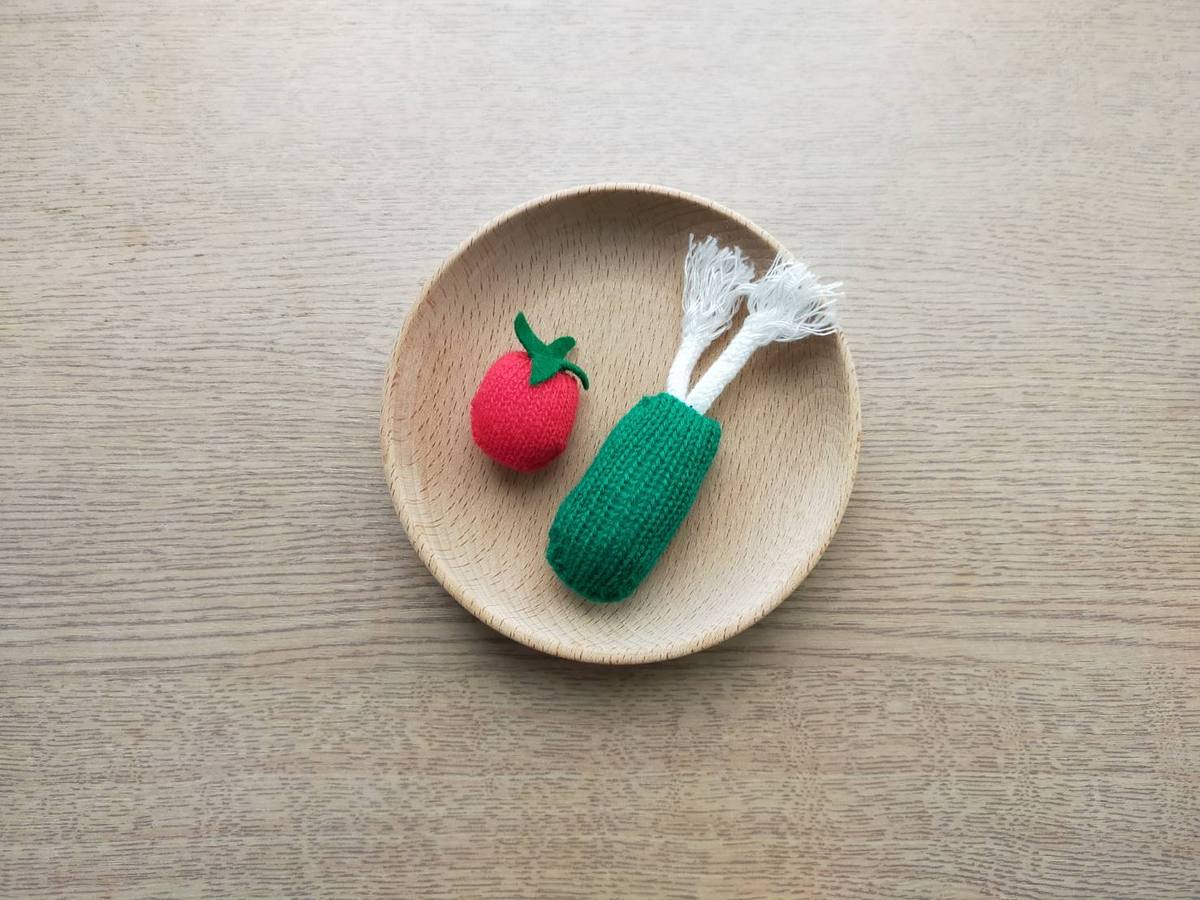 おままごとの具材。軍手で作ったプチトマトと野菜がおままごと用のお皿に乗っている。