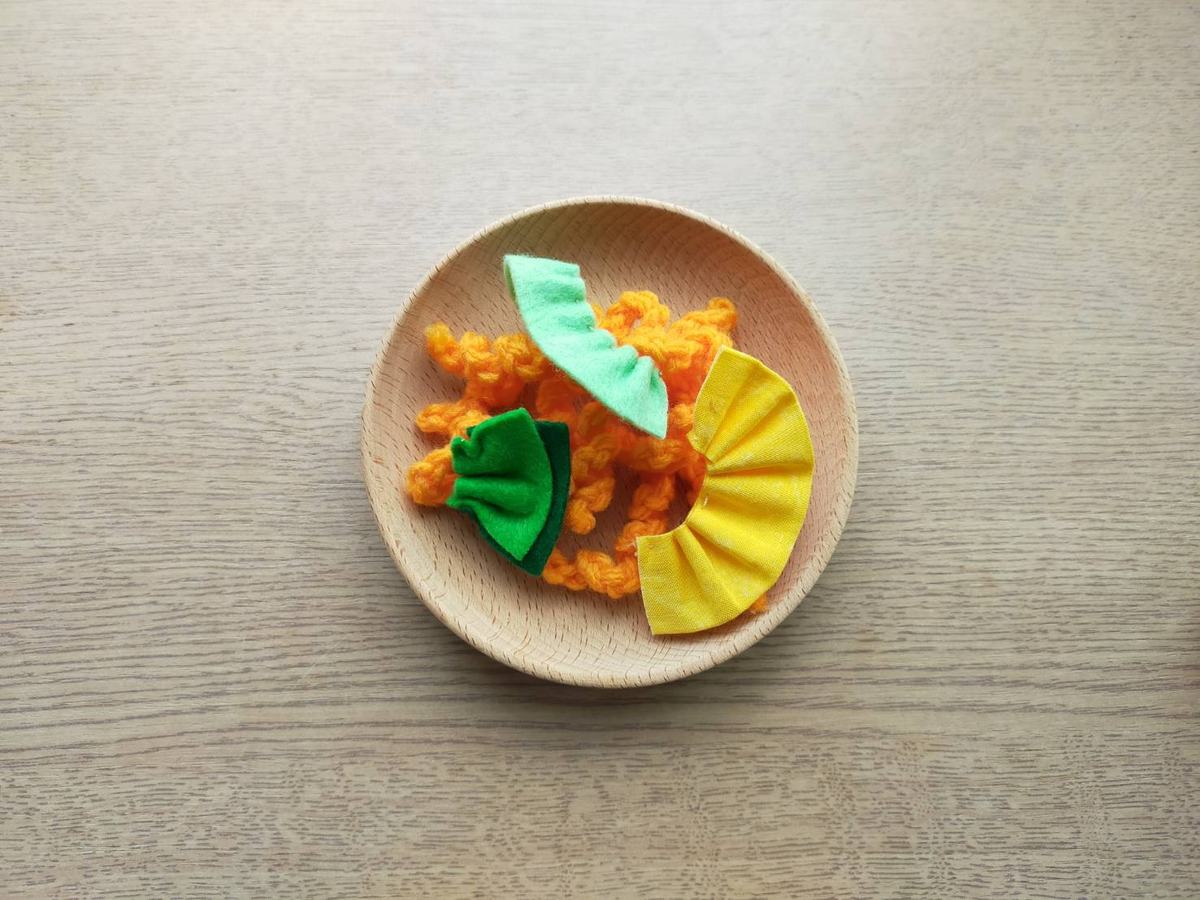 おままごとの具材。毛糸で作っためん、フェルトで作った具を乗せてスパゲッティ。見立て遊びで使う。