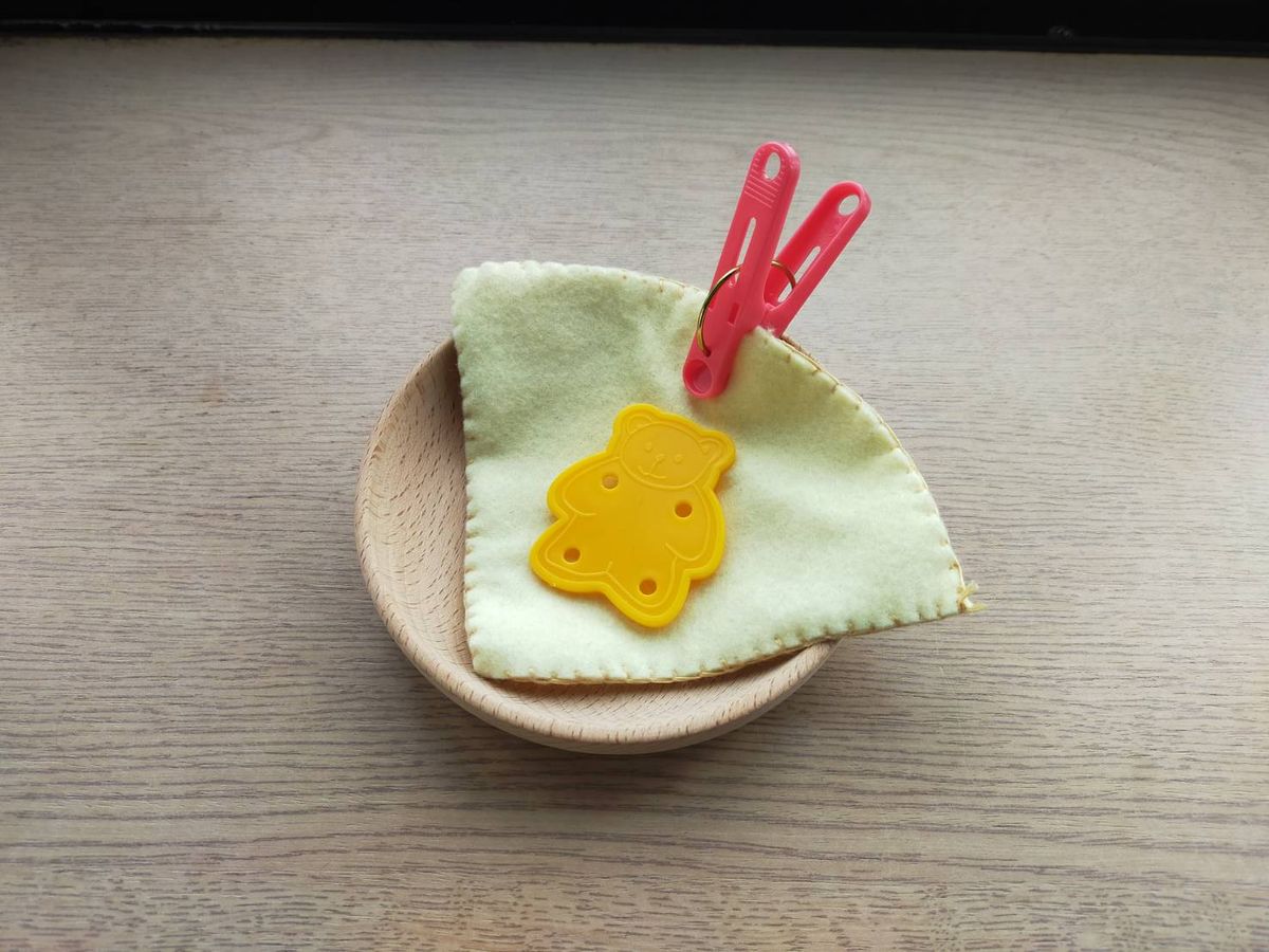 木のお皿にのせたフェルトを赤い洗濯ばさみでとめたおままごと