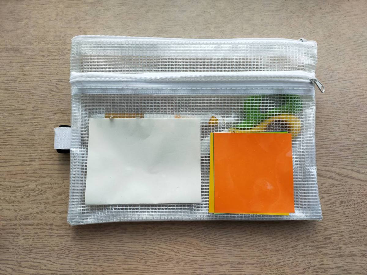 メッシュケースに折り紙とメモ帳を入れて持ち歩く様子